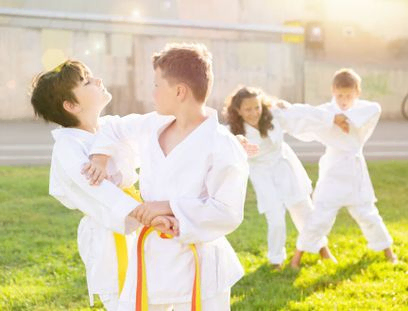 niños practicando judo al aire libre